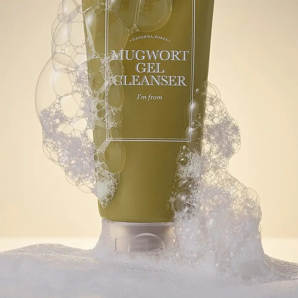 Tubo verde circondato da schiuma. Scritta: MUGWORT GEL CLEANSER, I'M FROM.