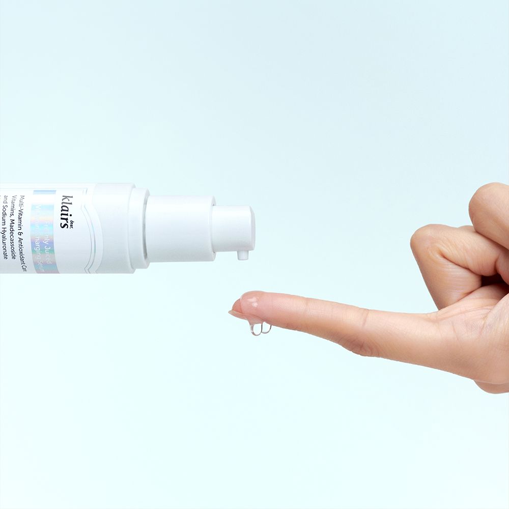 Flacone di siero bianco, goccia di siero sul dito. Scritta: klairs. Sfondo: azzurro.