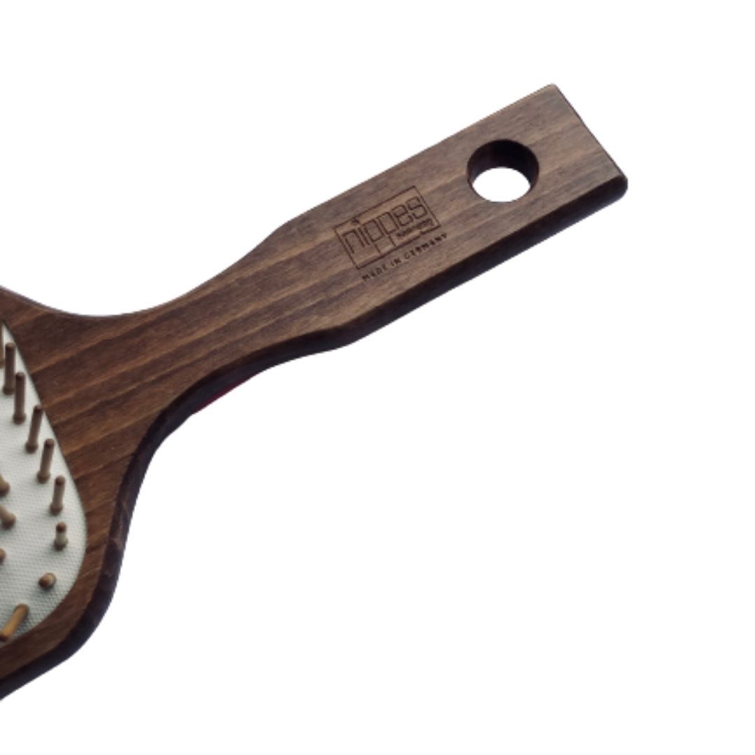 Dettaglio del manico di una spazzola per capelli. Legno, con foro. Marchio Nippes, Made in Germany.