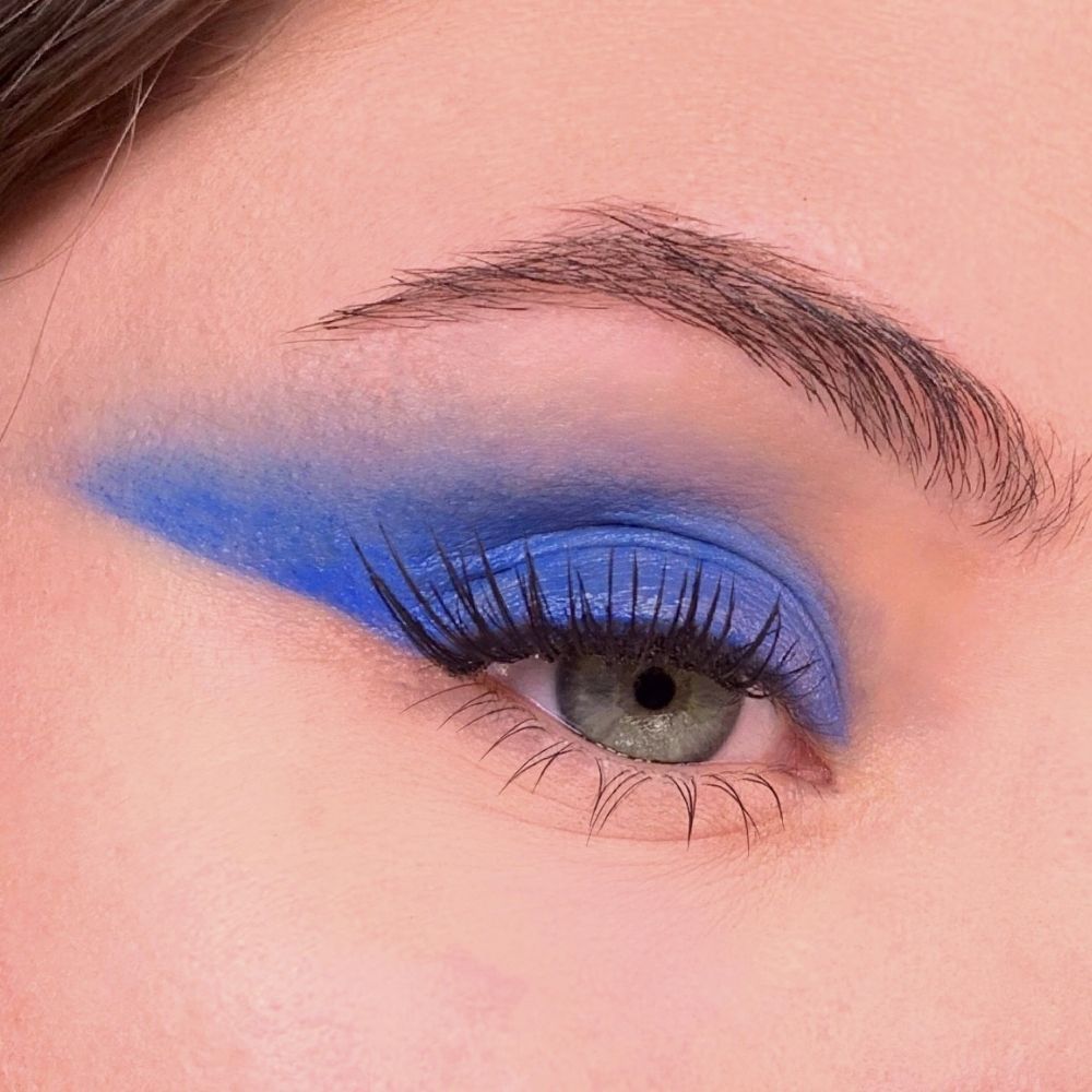 Occhio con ombretto blu. Blu applicato sulla palpebra e come eyeliner. Ciglia e sopracciglia visibili.