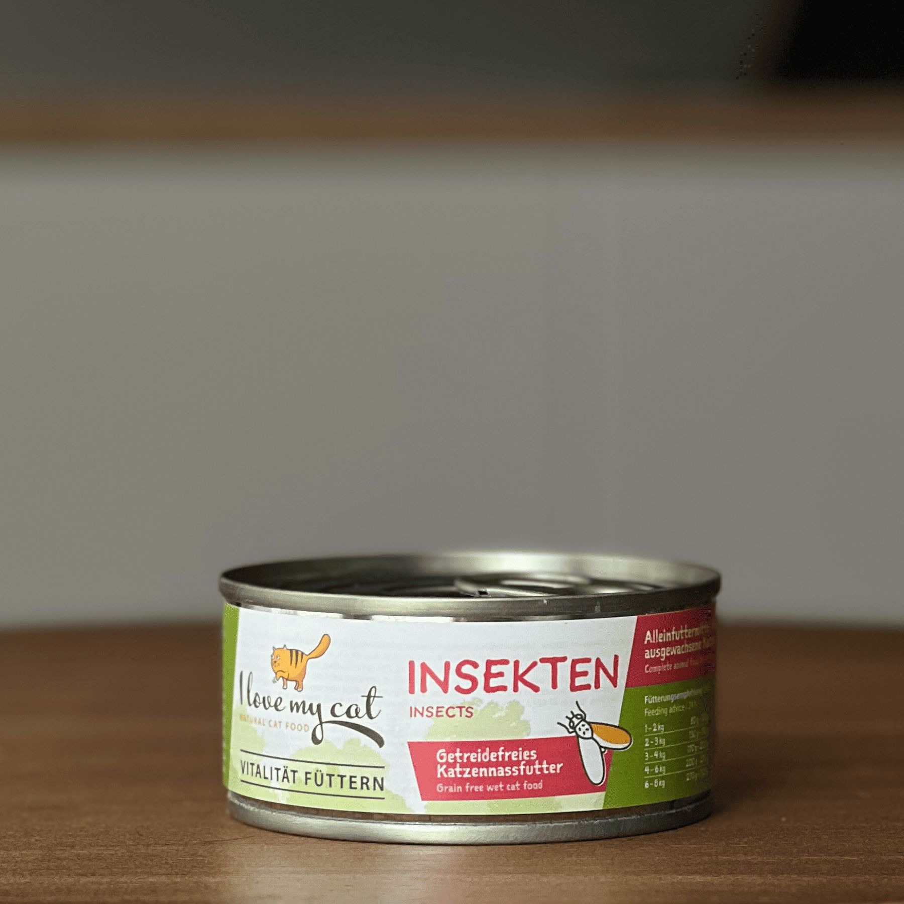 Lattina di cibo per gatti con etichetta verde. Scritta: I love my cat, Insekten. Cibo per gatti senza cereali. Lattina davanti a sfondo sfocato.