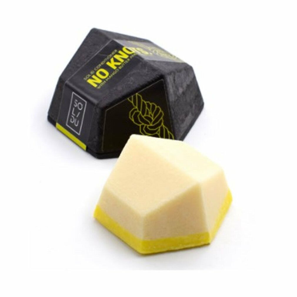 Balsamo solido ottagonale giallo e bianco con bordo giallo, accanto a confezione nera con testo.