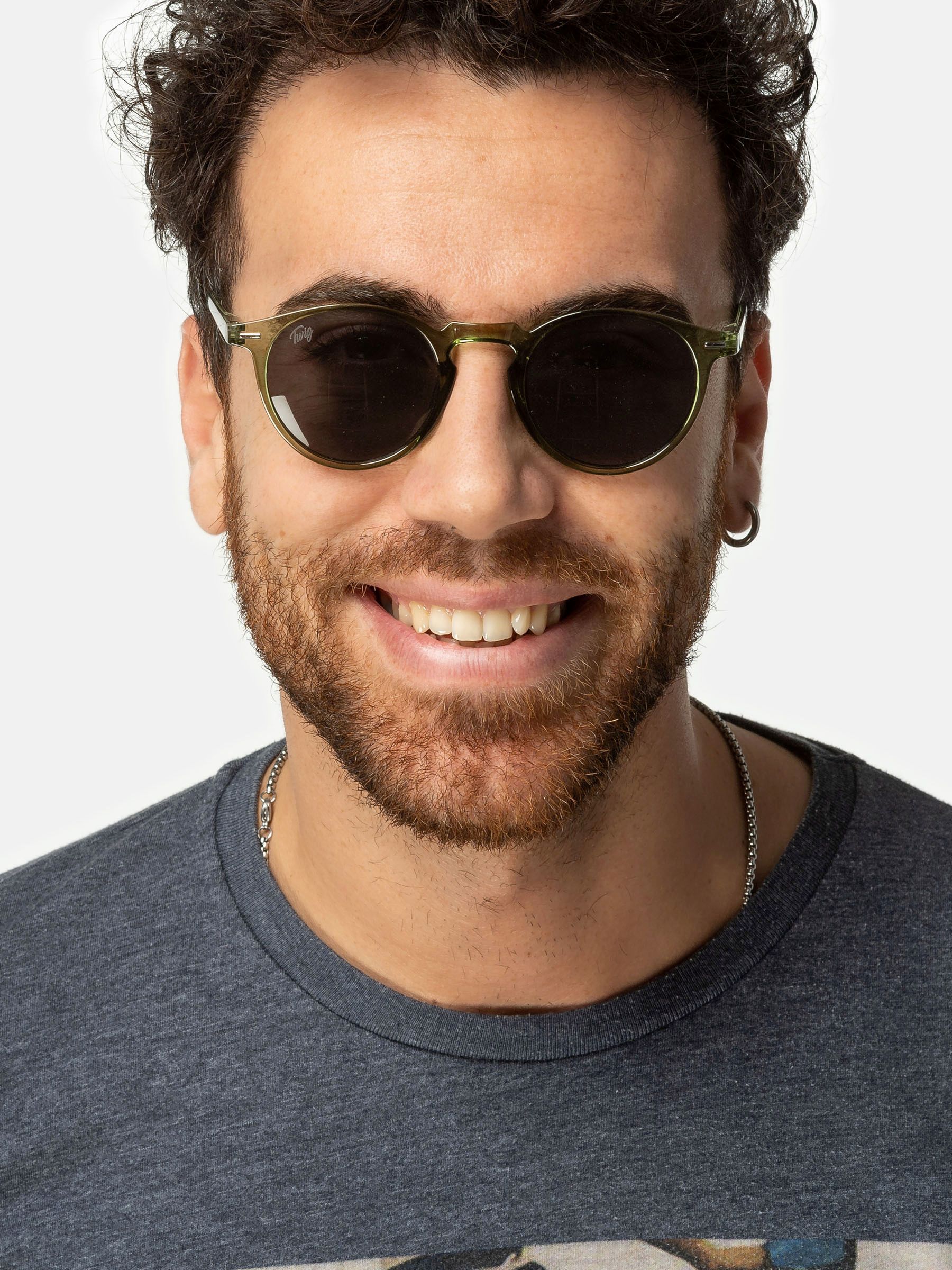 Uomo con occhiali da sole verdi. Primo piano. Sorride.
