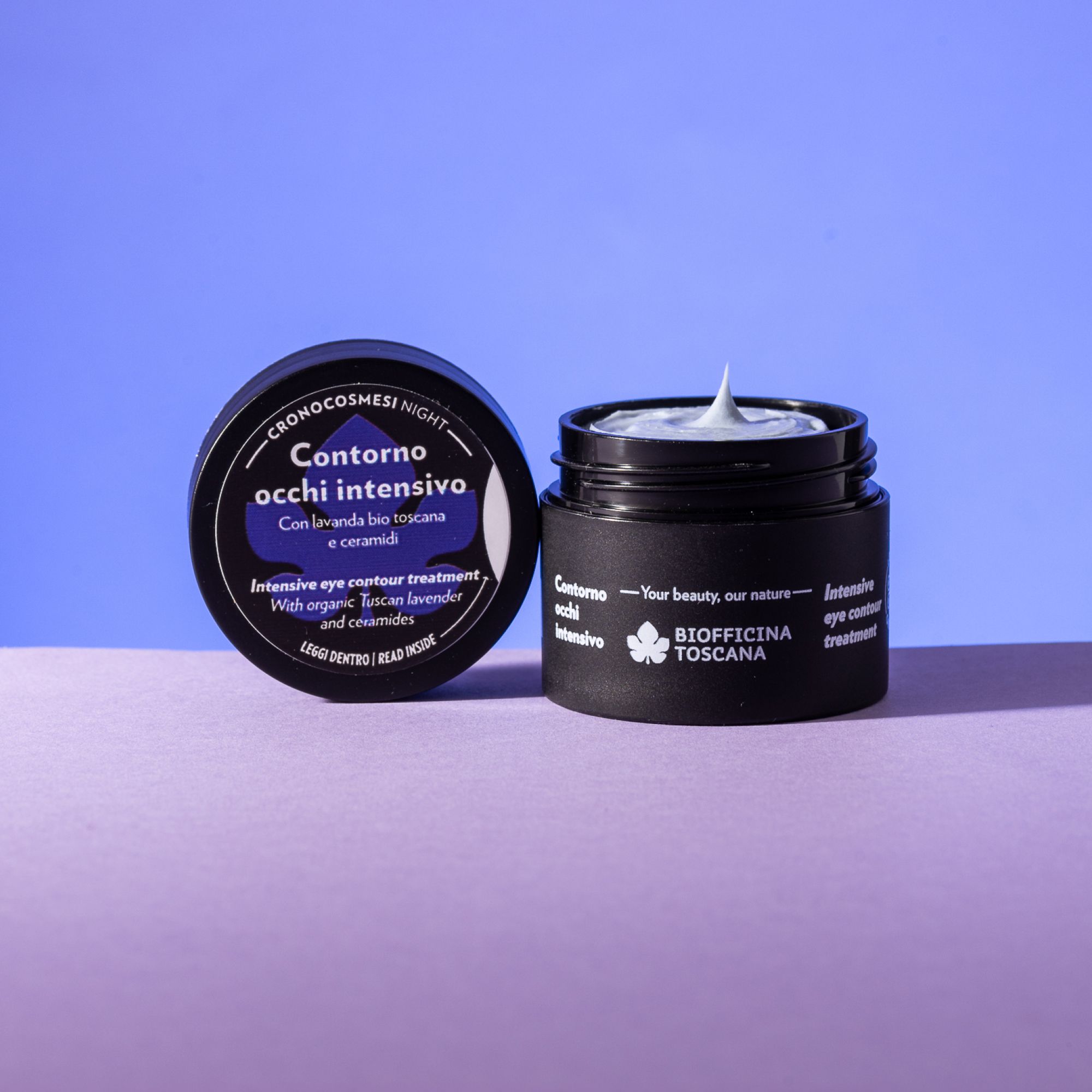 Vaso nero con crema, accanto il coperchio. Sul coperchio, "Contorno occhi intensivo".