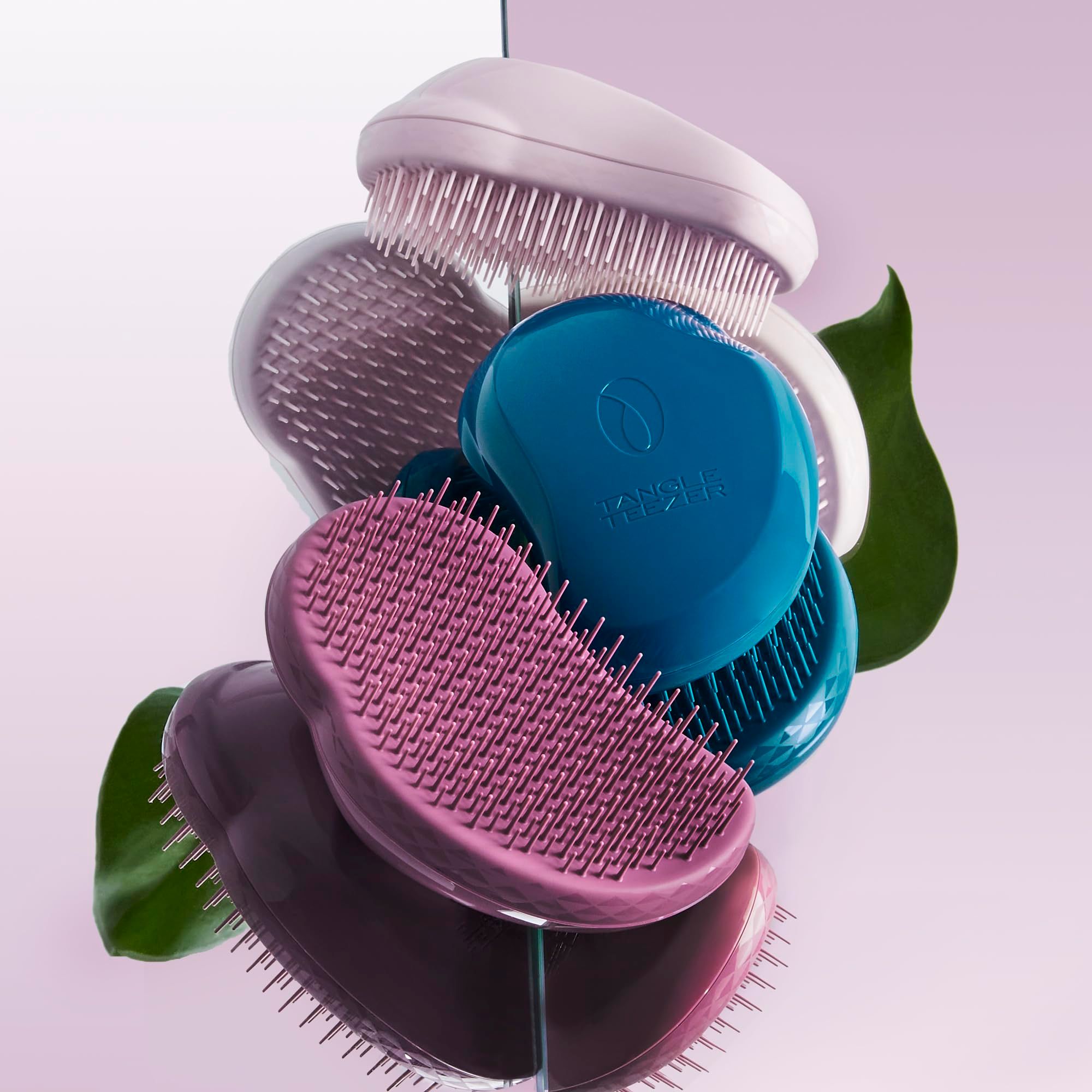 Diverse spazzole per capelli di vari colori. Alcune sono rosa, blu e viola.