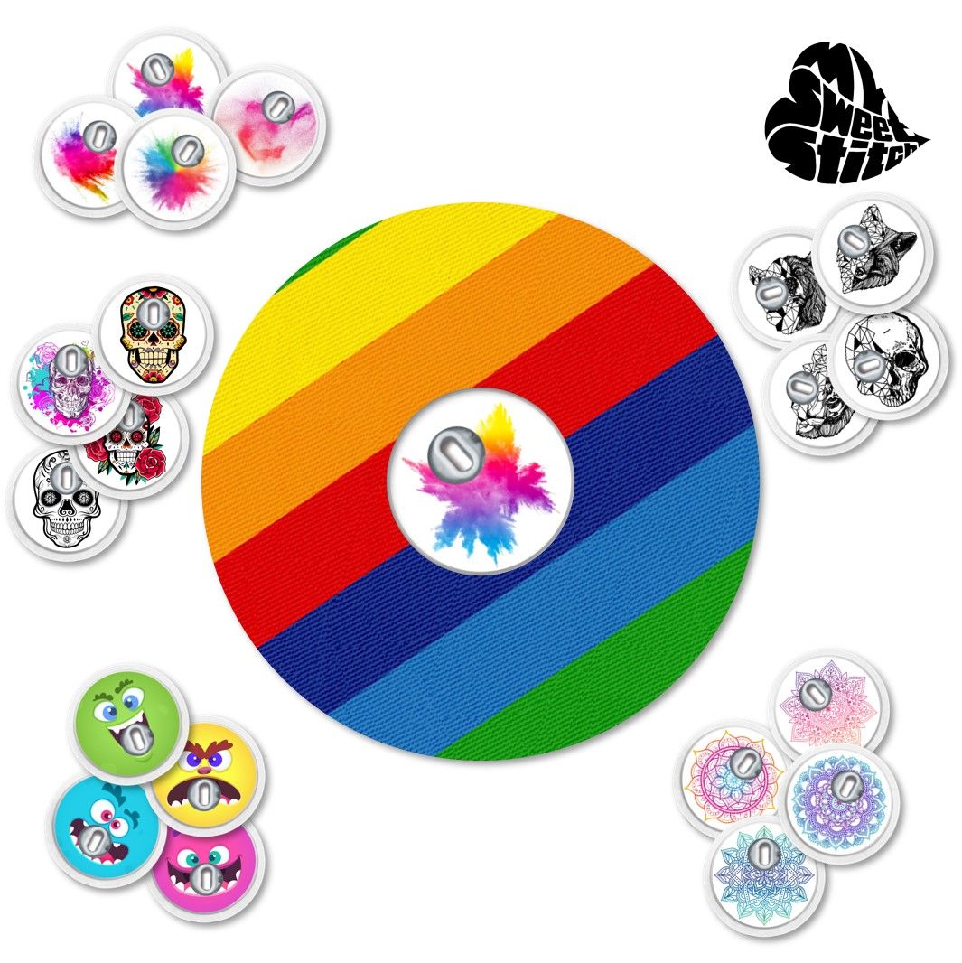 Vari anelli di fissaggio rotondi con disegni, tra cui uno arcobaleno e altri motivi.