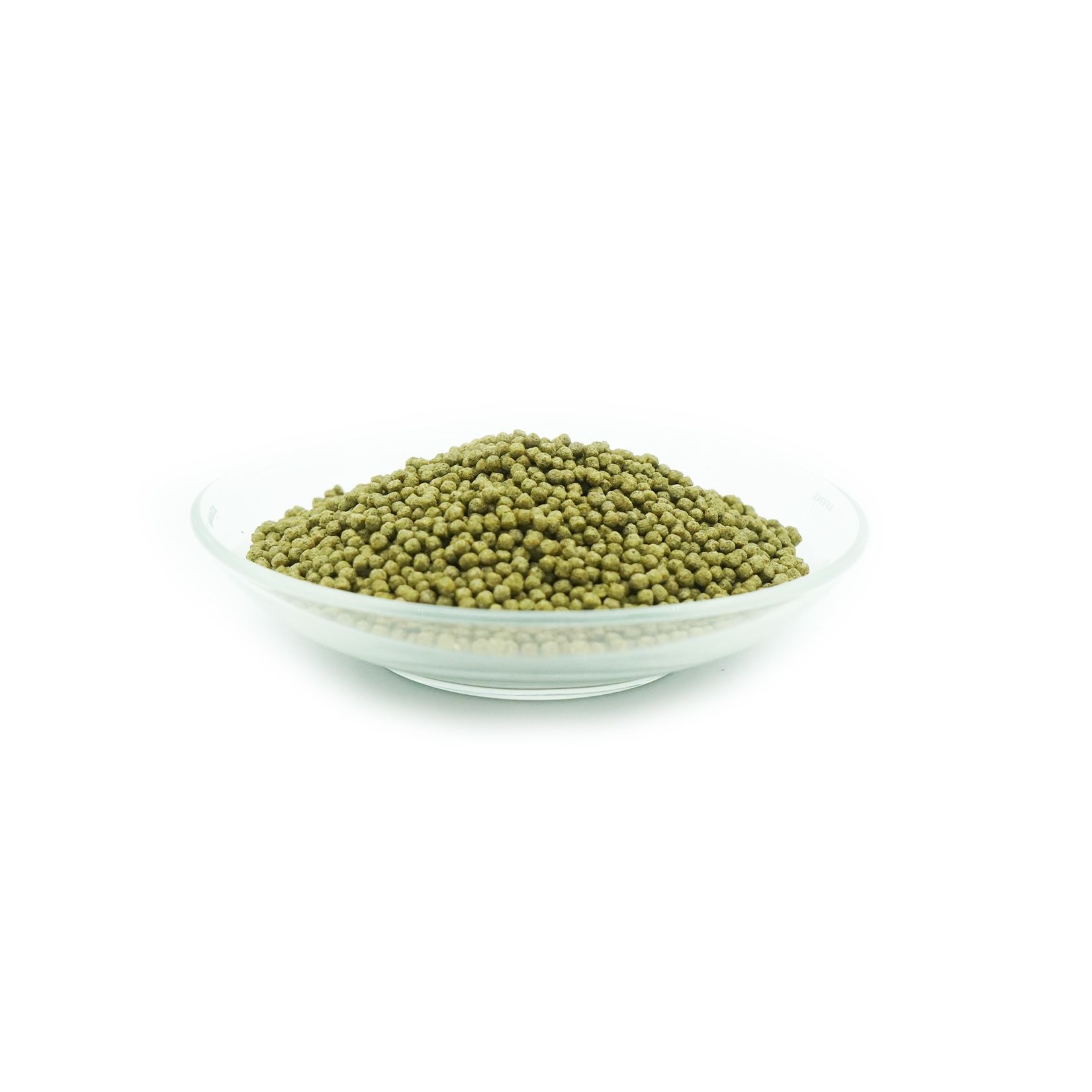 Pellet verdi per mangime per pesci in una ciotola di vetro. I pellet sono piccoli e numerosi.