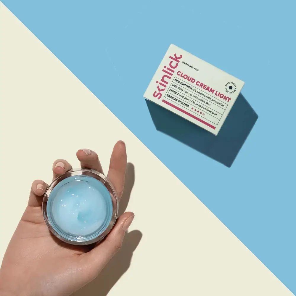 Crema chiara in un barattolo di vetro, tenuta in mano. Accanto, una scatola con informazioni sul prodotto.