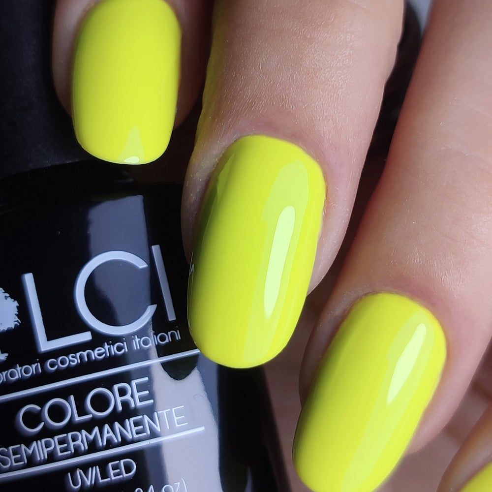 Mano con unghie smaltate di giallo. Flacone con logo LCI e scritta Colore Semipermanente.