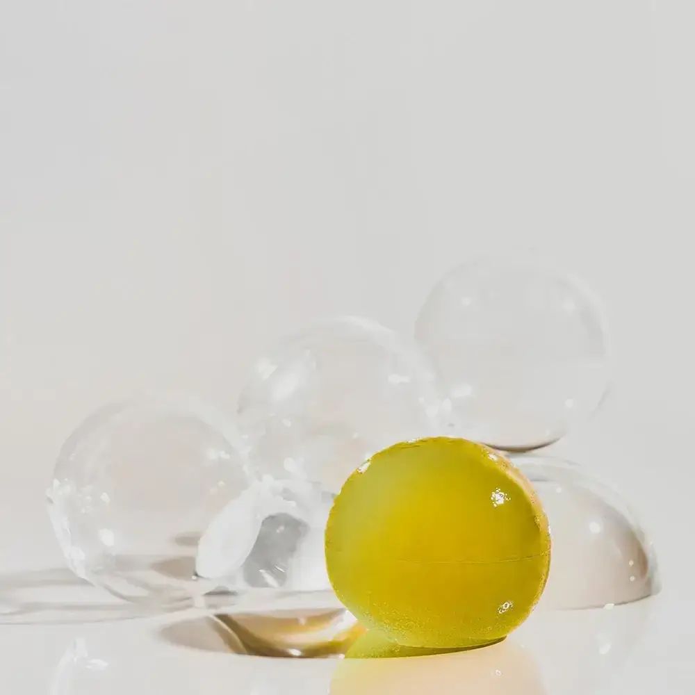 Sfera gialla con sfere trasparenti. Su sfondo bianco.