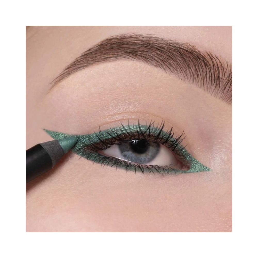 Occhio con eyeliner verde. Una matita viene utilizzata per tracciare una linea. La matita è nera.