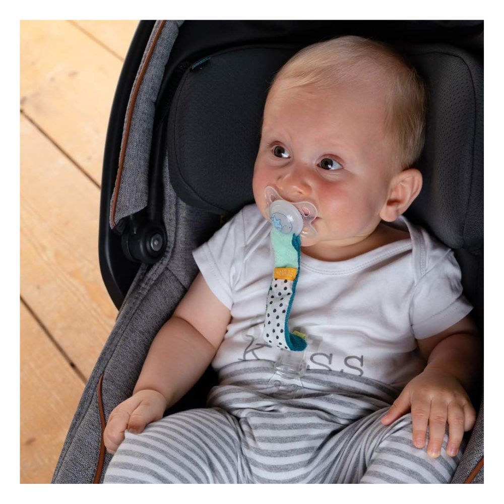Bambino con ciuccio e portaciuccio Minze in seggiolino auto. Bambino indossa una maglietta stampata.