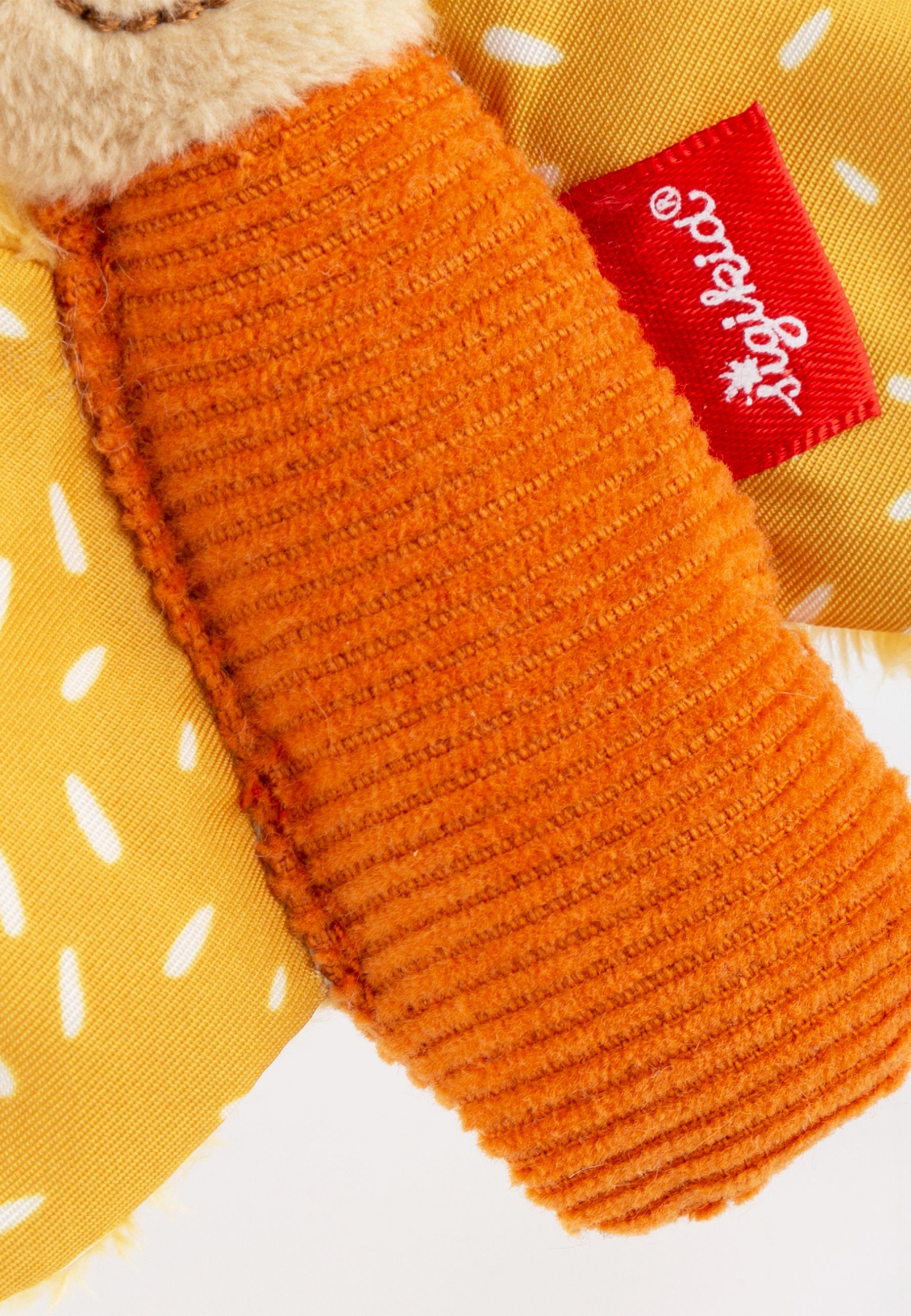 Primo piano del corpo arancione e di un'ala della farfalla. Etichetta rossa "sigikid". Ala gialla con punti bianchi.