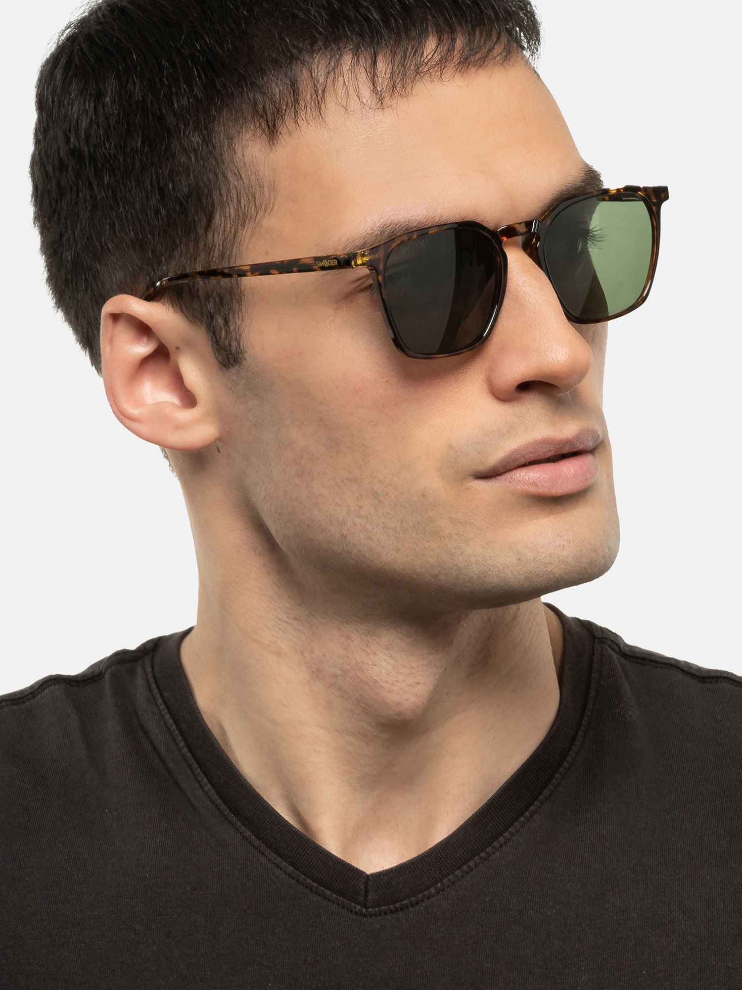 Uomo con occhiali da sole tartarugati marroni e lenti verdi.