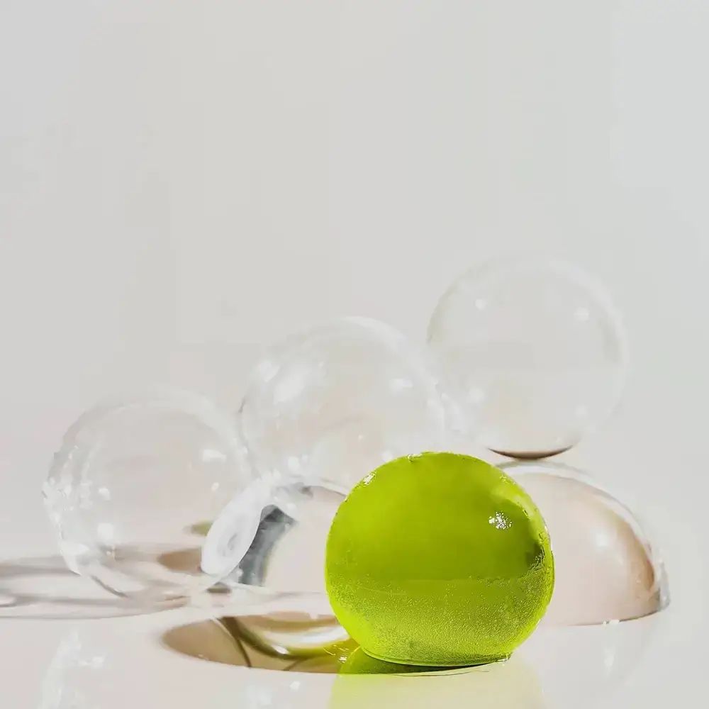 Oggetto sferico verde con sfere trasparenti.