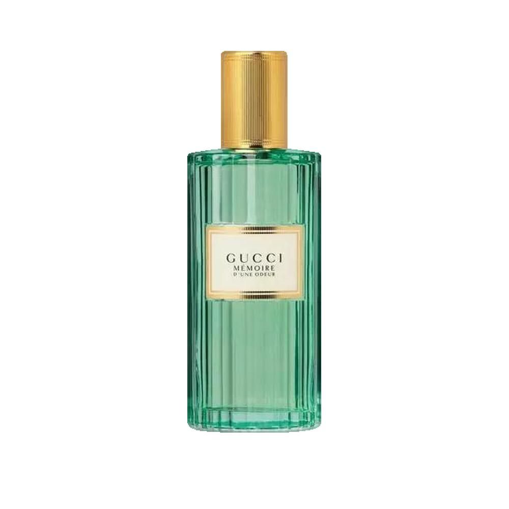 Flacone di profumo in vetro verde con tappo dorato. Etichetta con scritta Gucci Mémoire d'une Odeur.