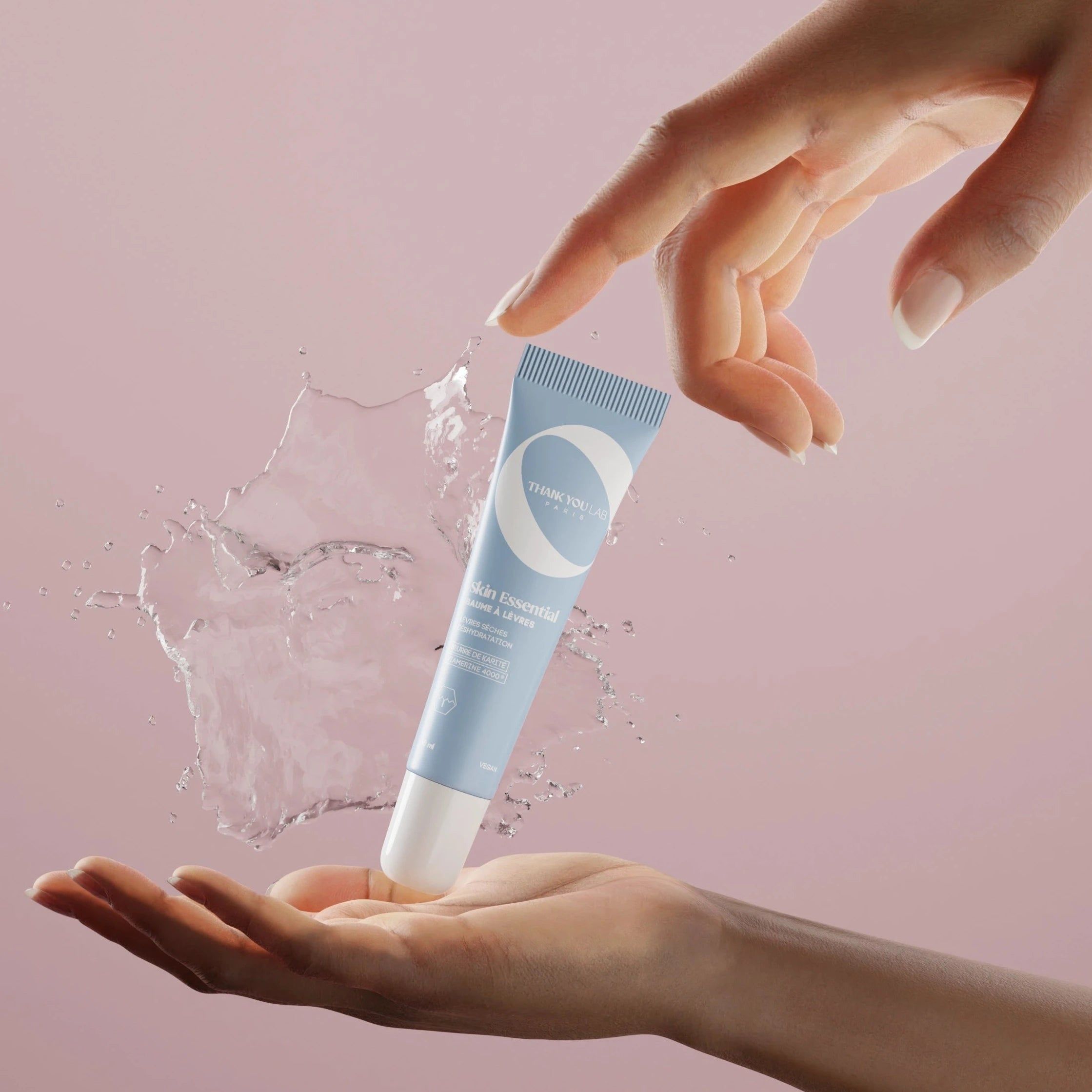 Tubo azzurro chiaro con spruzzi d'acqua. Mani che tengono il tubo. Scritta visibile.