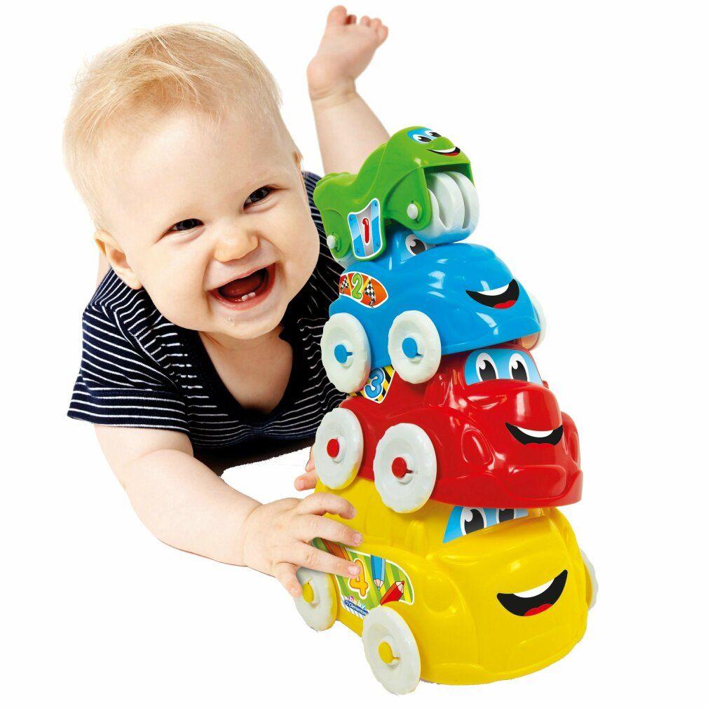 Un bambino accanto a un giocattolo a forma di auto impilabili. Il giocattolo è giallo, rosso, blu e verde. Il bambino sorride.