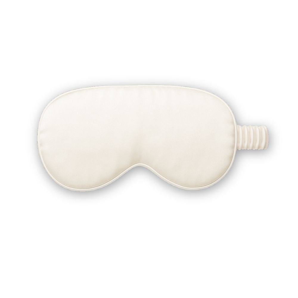 Maschera per dormire color crema in seta. Con fascia elastica. Su sfondo bianco.
