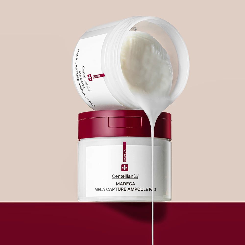 Due barattoli bianchi con coperchi rossi. Uno aperto, mostra pad e liquido. Nome del prodotto e marchio stampati.