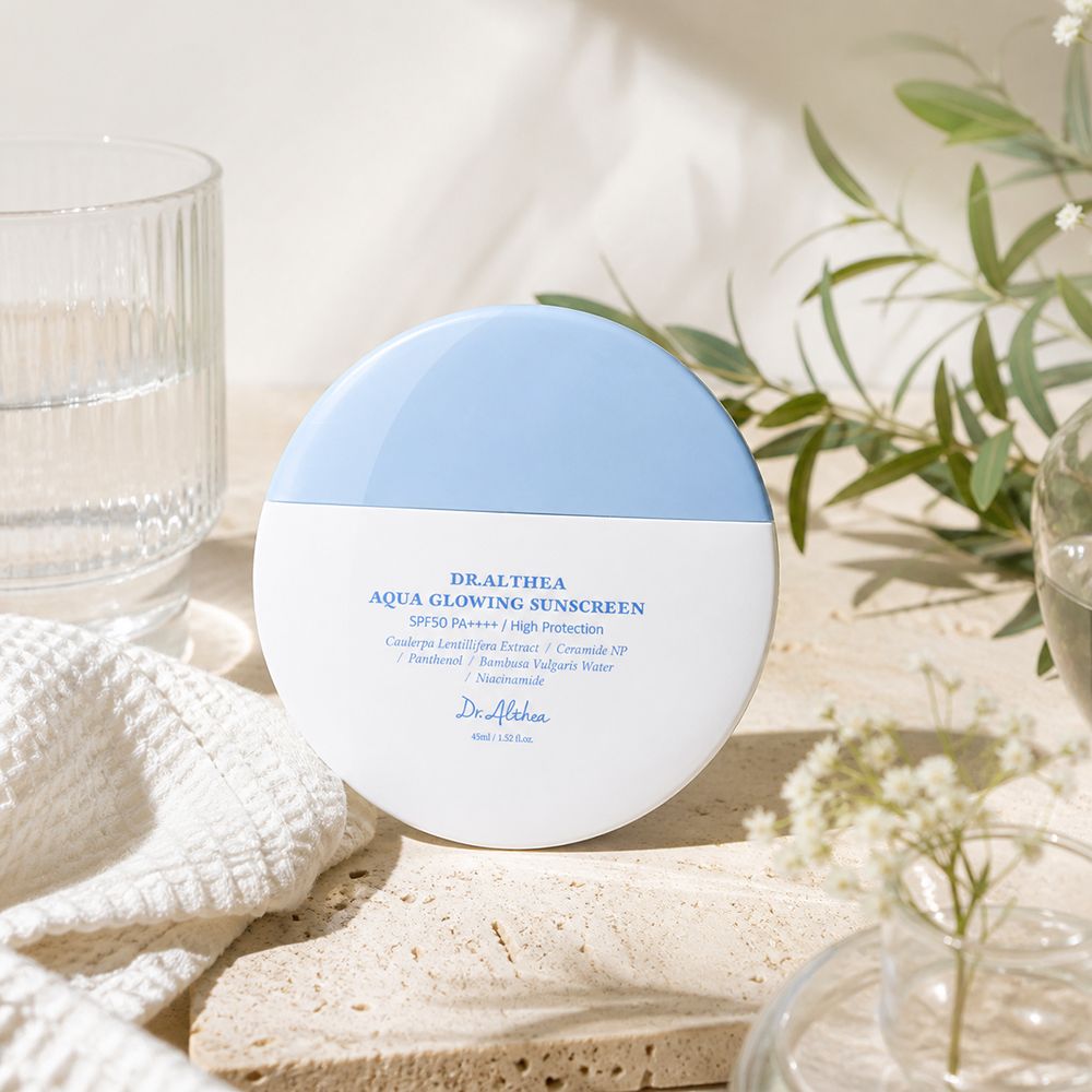 Crema solare Dr. Althea Aqua Glowing in contenitore bianco e blu, con testo.