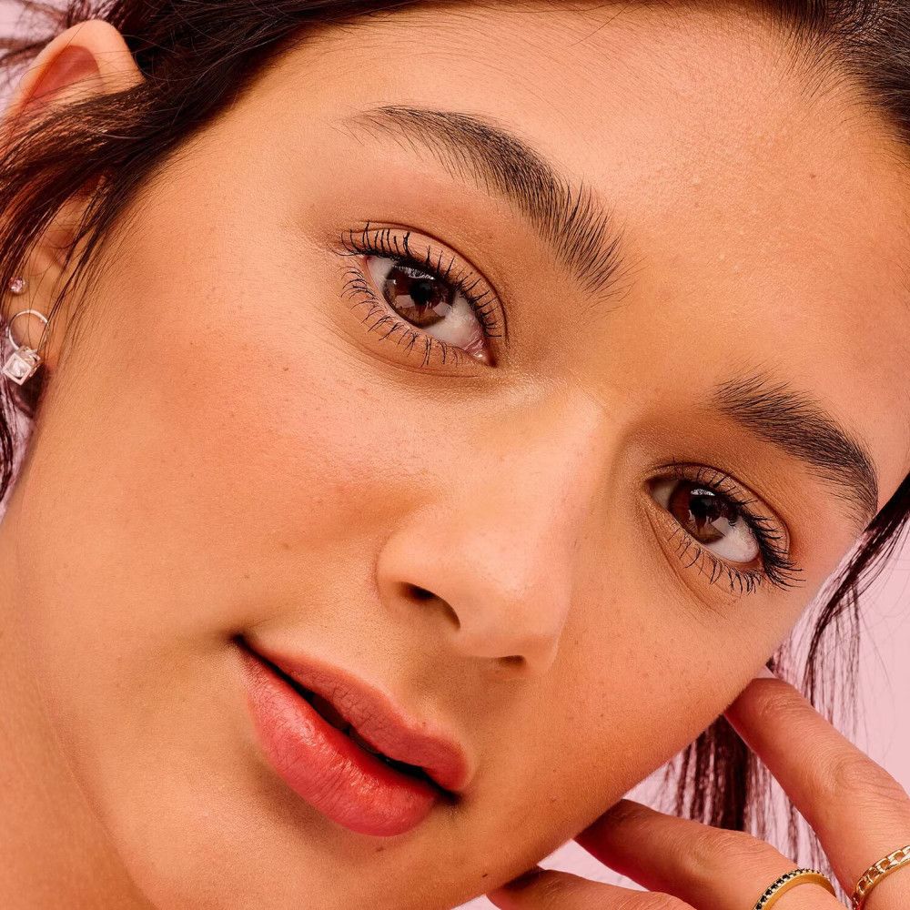 Primo piano di un viso con mascara. Gli occhi sono aperti. Le ciglia sono truccate.