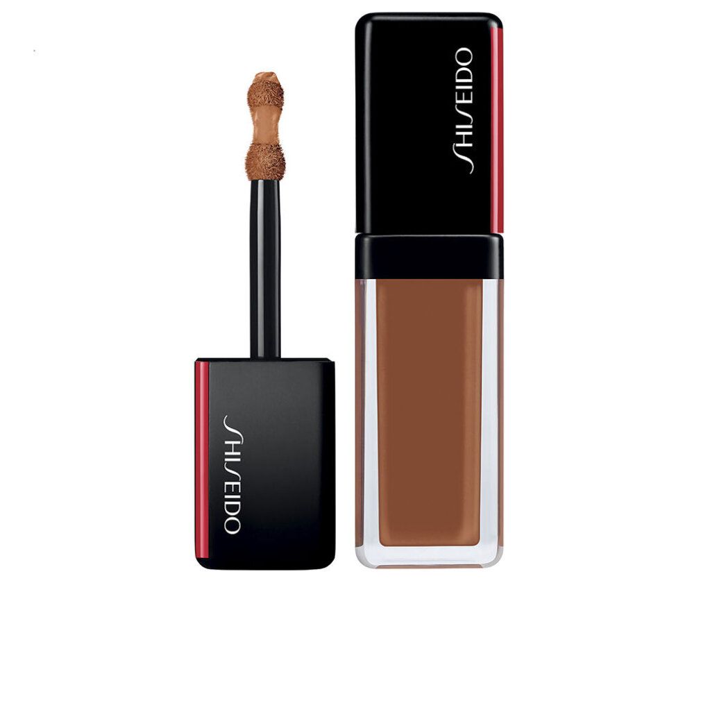 Flacone di correttore beige con tappo nero. Applicatore visibile. Logo Shiseido sul tappo.