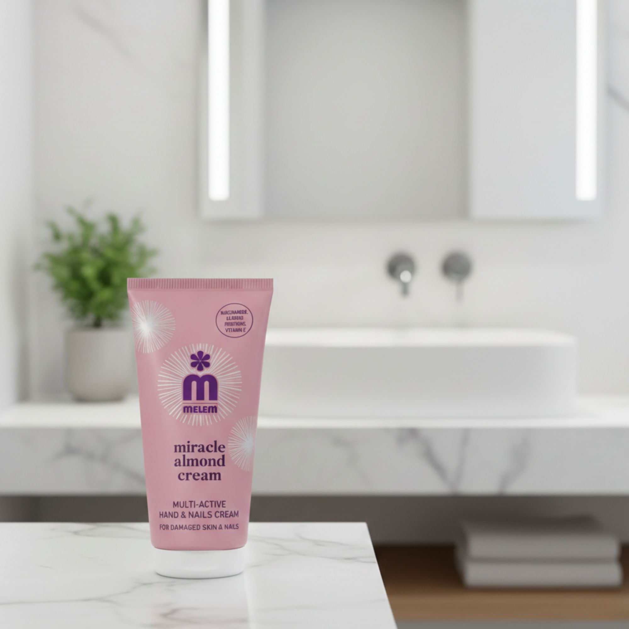 Tubo rosa "melem miracle almond cream" su marmo. Testo: Multi-Active Hand & Nails Cream. Per pelli e unghie danneggiate. Con olio di mandorle.