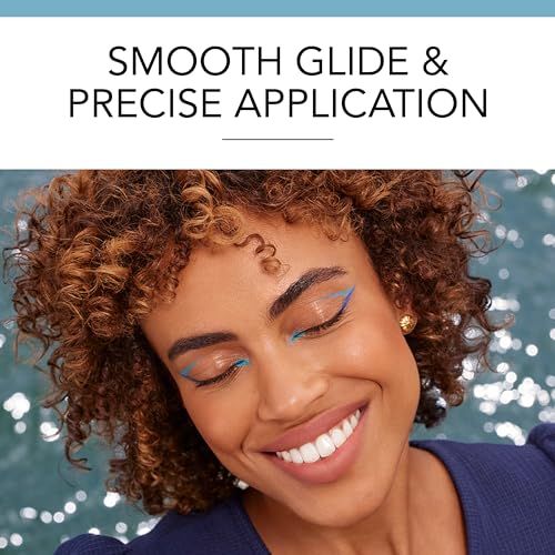 Donna con accenti di eyeliner blu sulle palpebre e un sorriso.