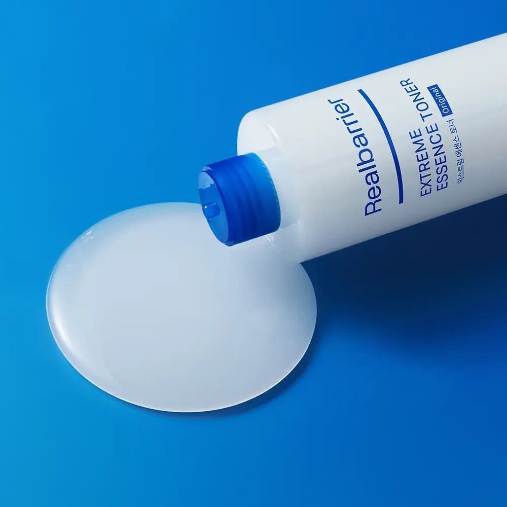 Flacone bianco con tappo blu, liquido versato. Nome del prodotto e testo visibili.