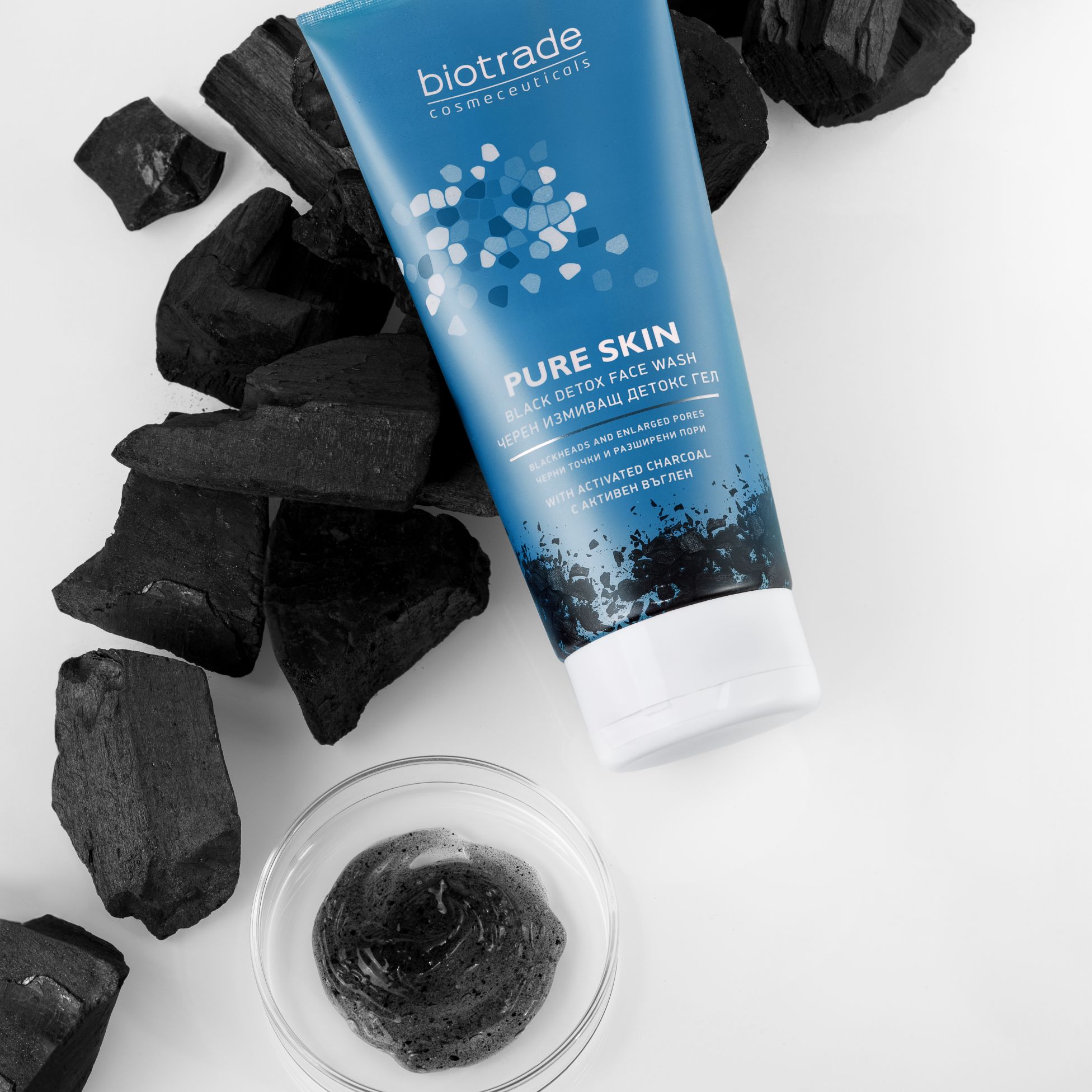 Tubo blu con tappo bianco e carbone. Ciotola con gel nero. Scritta: Biotrade, Pure Skin Black Detox Face Wash.
