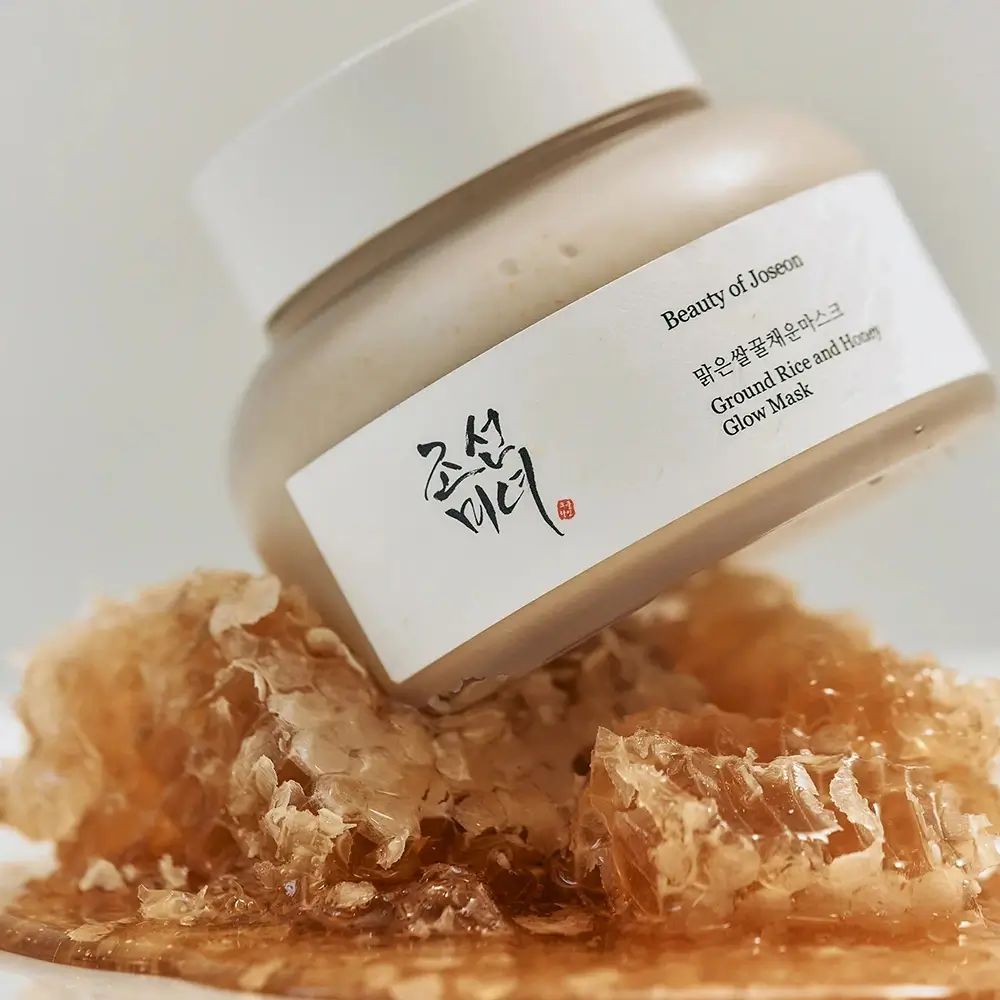 Prodotto accanto a favo. Prodotto: Ground Rice and Honey Glow Mask. Scritta: Beauty of Joseon.