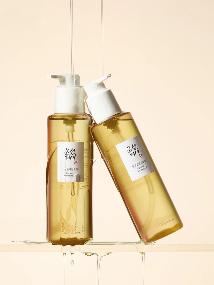 Due flaconi di Beauty of Joseon Revive Serum, uno in piedi, l'altro sdraiato, con gocce di siero.