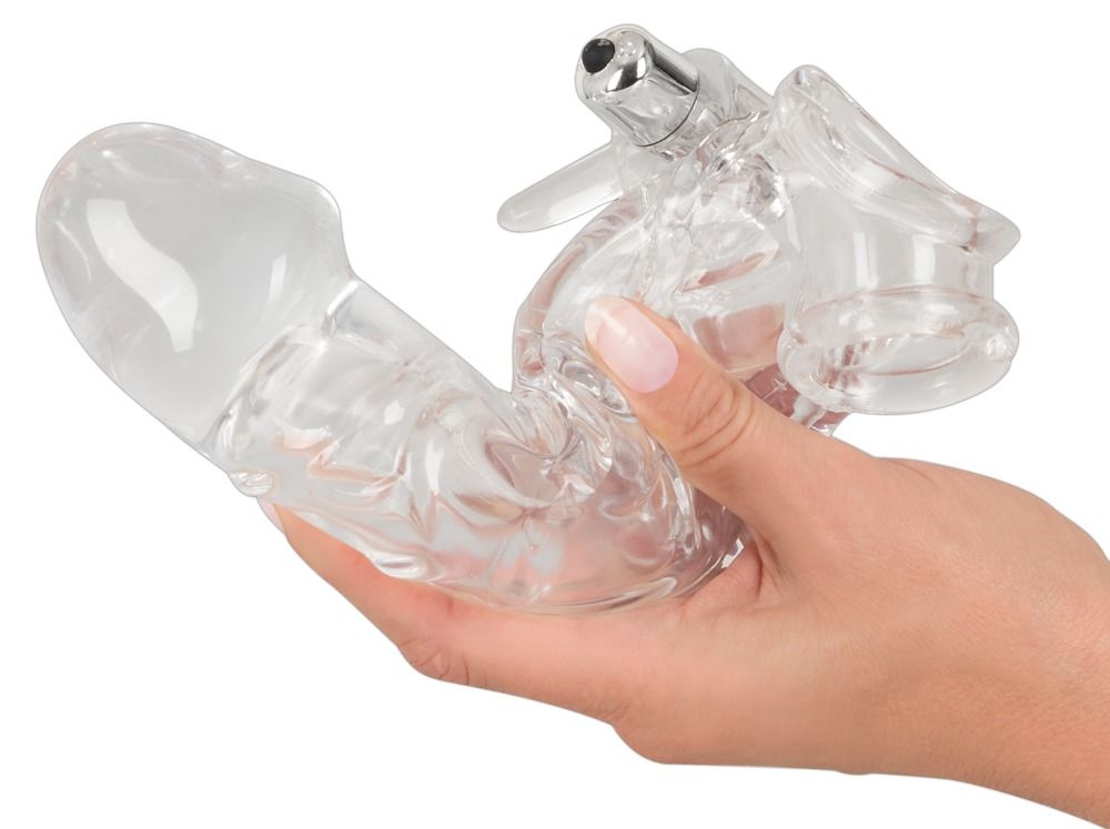 Manicotto per pene trasparente tenuto in mano. Forma di pene con ali. Funzione vibrante visibile.