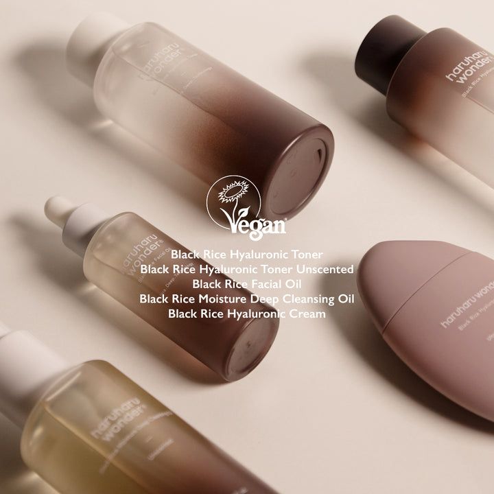 Diversi prodotti su una superficie. Flaconi di toner, olio per il viso e crema. Sigillo vegano. Scritta: Haruharu wonder.