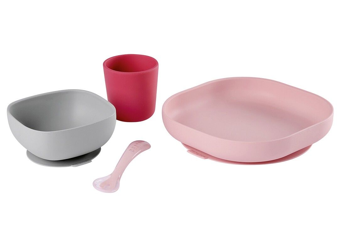 Piatto rosa, ciotola grigia, tazza rosa e cucchiaio in silicone. Tutti disposti separatamente.