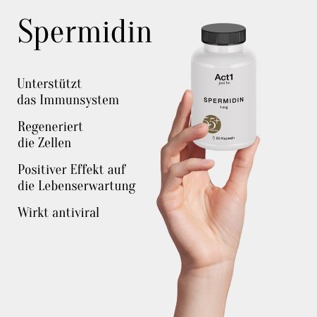 Flacone bianco, tappo nero, Spermidin 1mg, Act1 just be. Mano che tiene il flacone. Testo: Supporta il sistema immunitario, rigenera le cellule, effetto positivo.