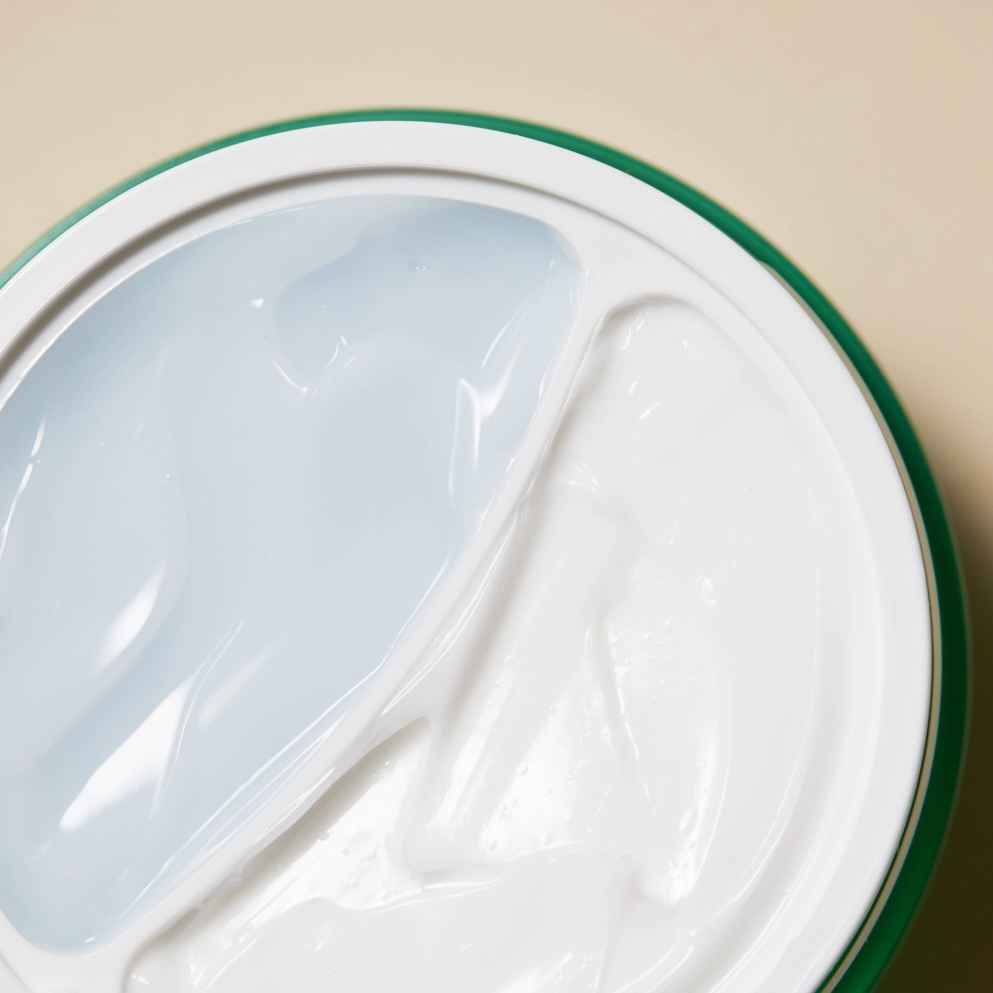 Primo piano della superficie della crema. Due aree distinte: una crema bianca e una texture gel trasparente.