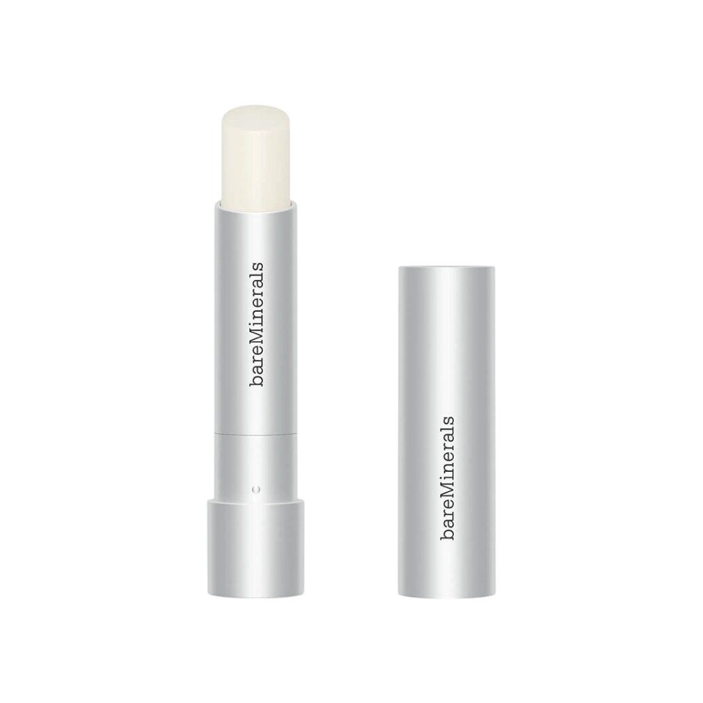 Stick labbra argentato con cappuccio aperto. Marchio: bareMinerals. Lo stick mostra il balsamo. Cappuccio accanto.