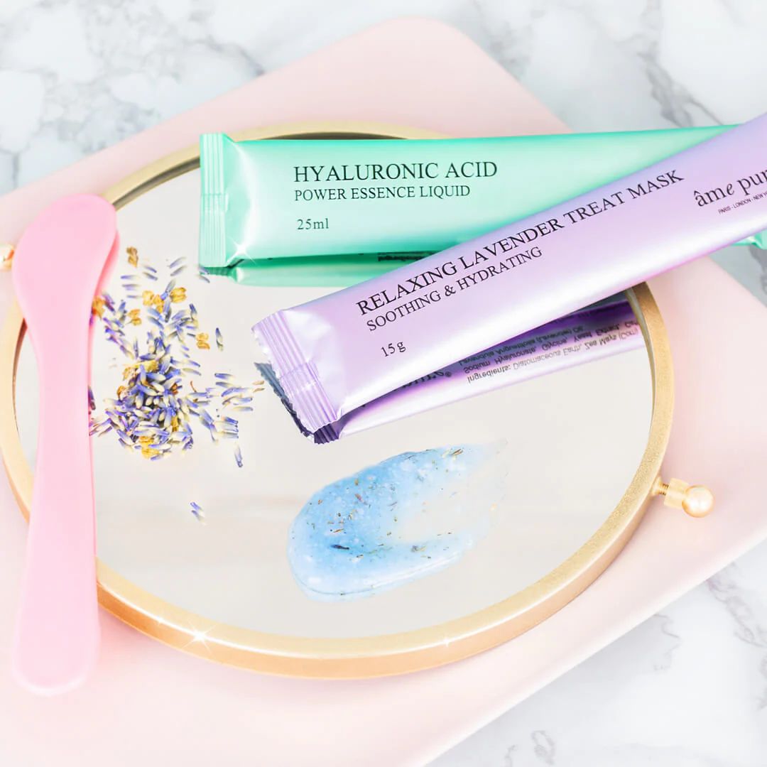 Specchio con due bustine di maschera, spatola e residui di maschera. Bustine: Acido Ialuronico e Relaxing Lavender Treat Mask.