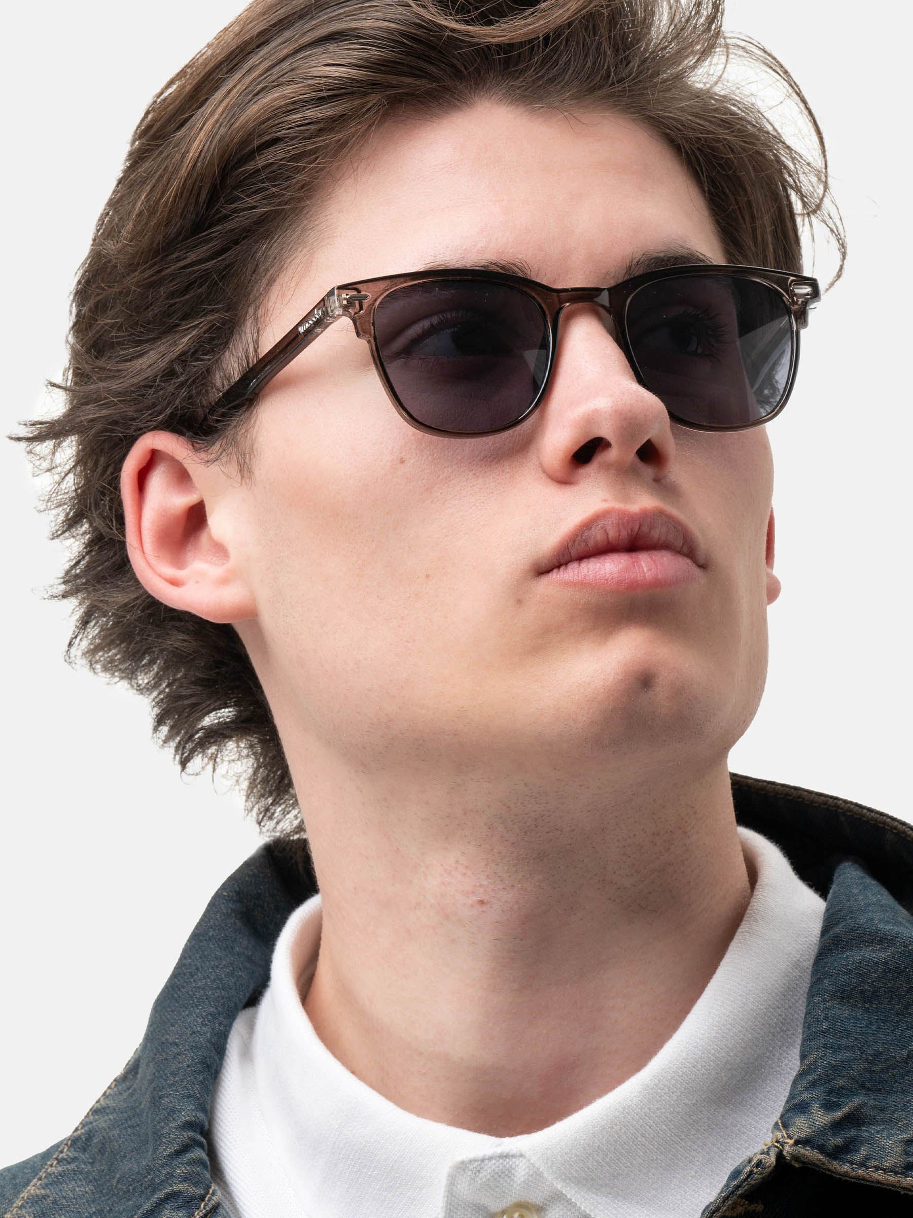 Uomo con occhiali da sole Sonora Gentle Grey. Montatura e lenti grigie. Logo Smooder sulla stanghetta.