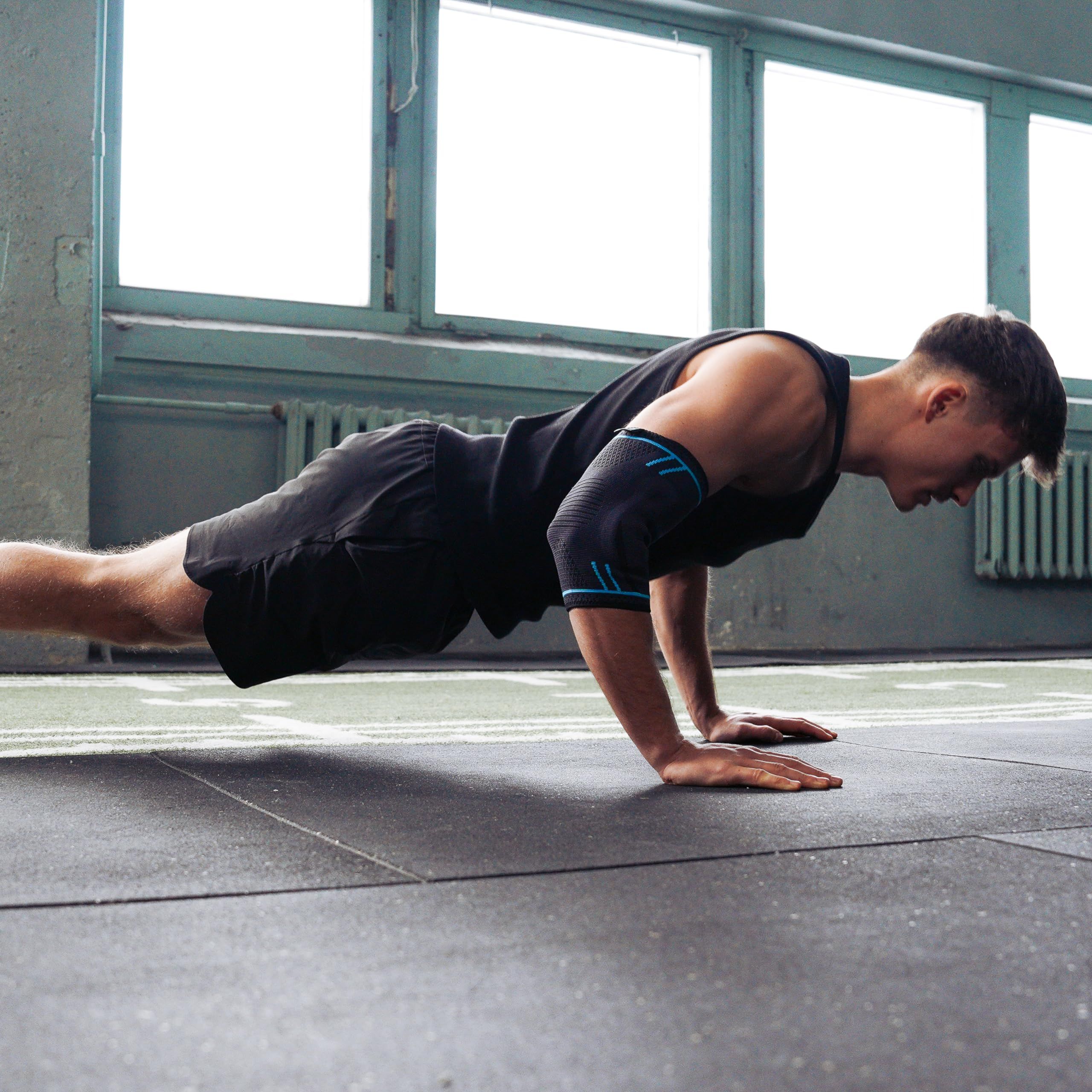 Uomo fa flessioni. Tutore per gomito. Ambiente palestra.