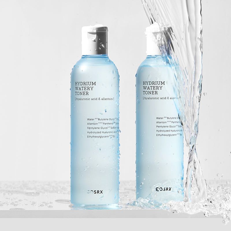 Due flaconi di toner per la pelle, liquido blu, tappo bianco. L'acqua schizza. Scritte: HYDRIUM WATERY TONER, ingredienti. Marchio COSRX.