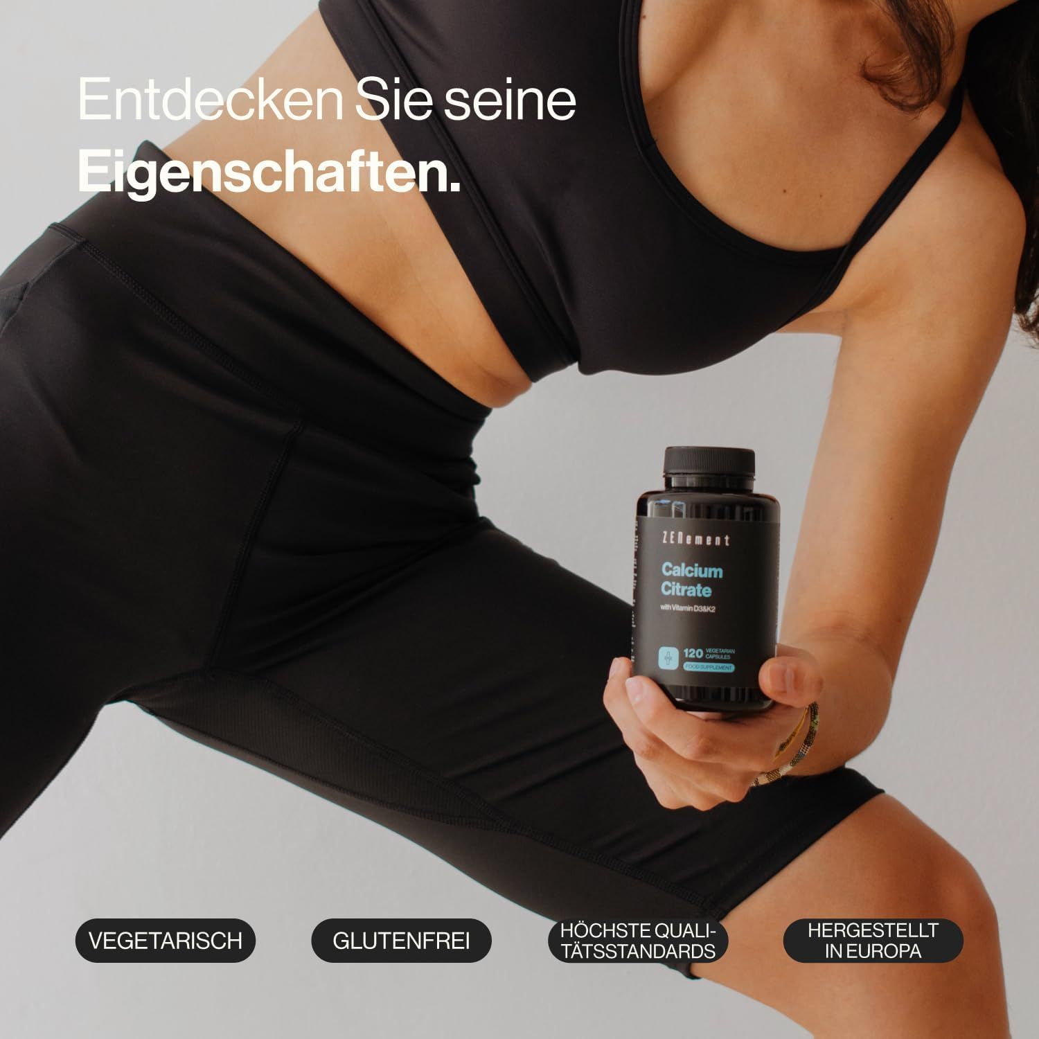 Persona tiene bottiglia nera di Zenement Calciumcitrat. Scritte: Vegetariano, Senza glutine, Standard di qualità, Prodotto in Europa.