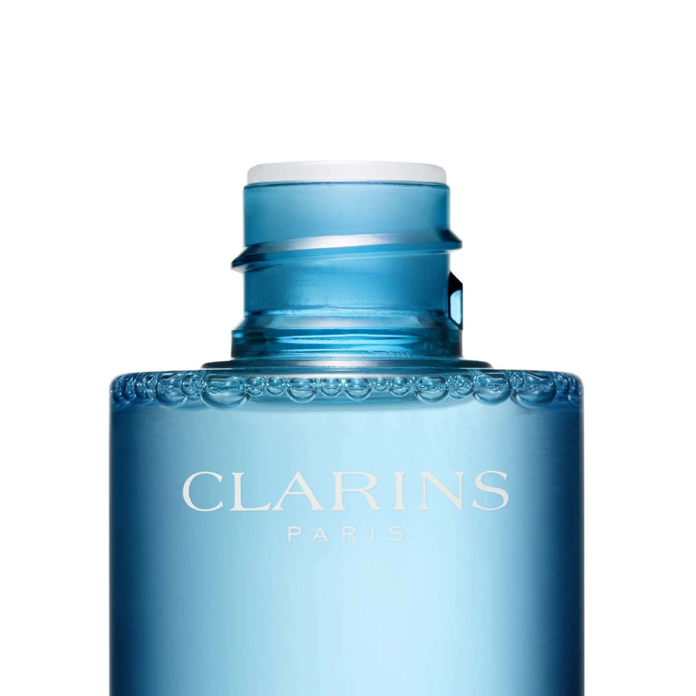 Primo piano dell'apertura del flacone. Testo: Clarins Paris. Flacone con contenuto blu e tappo bianco.