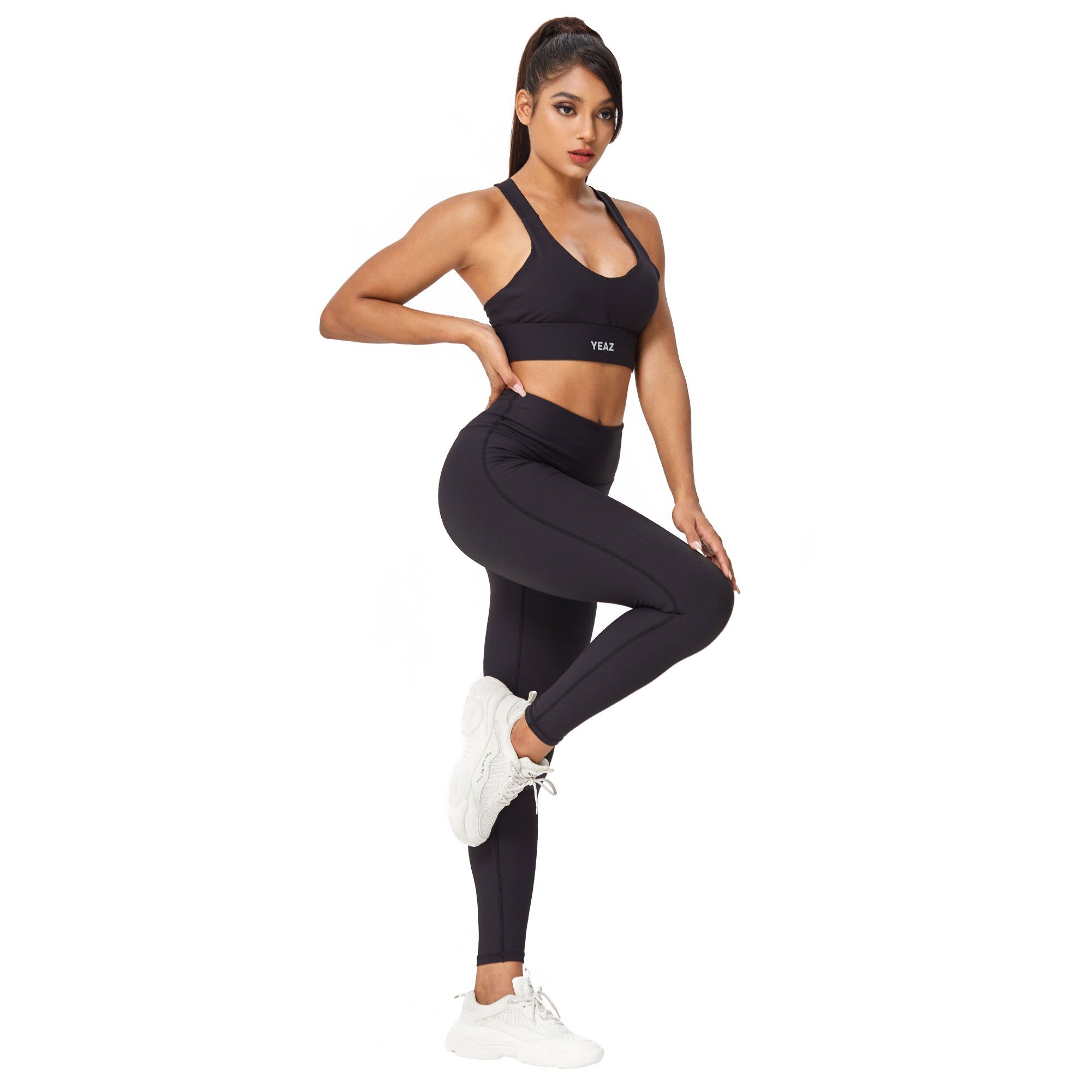 Donna in reggiseno sportivo nero e leggings, logo bianco sul reggiseno.
