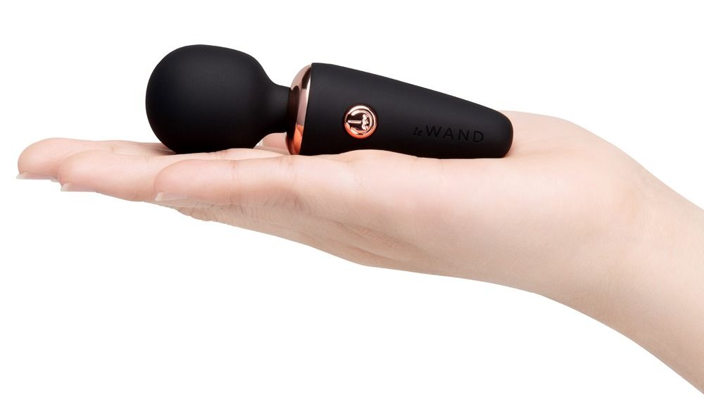 Vibratore nero con porta di ricarica in una mano.