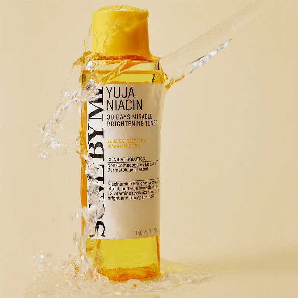 Flacone giallo con etichetta bianca. Testo: SOME BY MI, Yuja Niacin, 30 Days Miracle Brightening Toner. Spruzzi d'acqua.