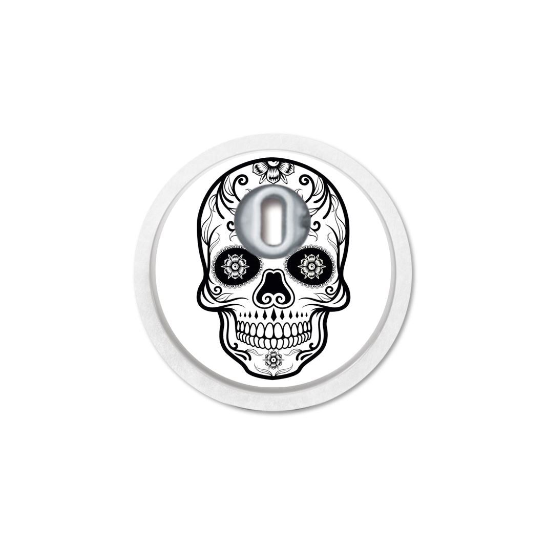 Adesivo rotondo con disegno di teschio. Apertura per sensore. Dettagli in bianco e nero. Bordo bianco.