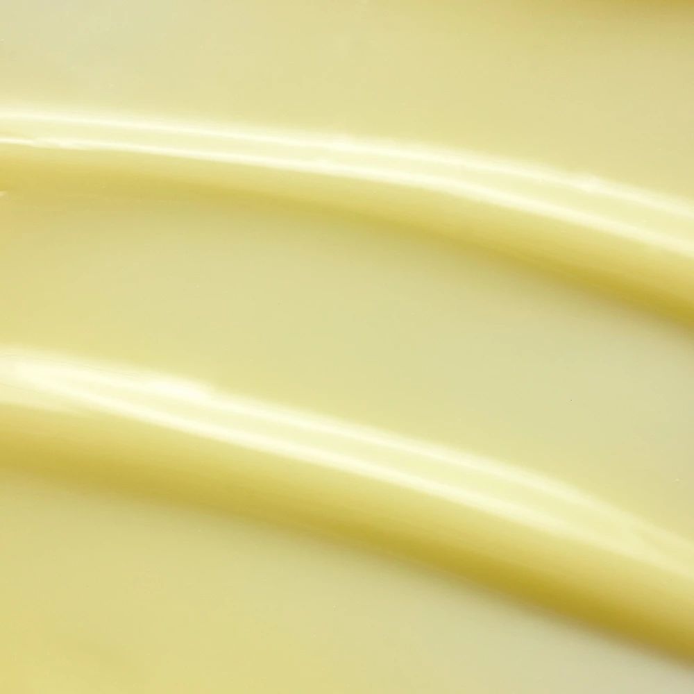 Primo piano di crema gialla. Due strisce ondulate. Texture liscia.